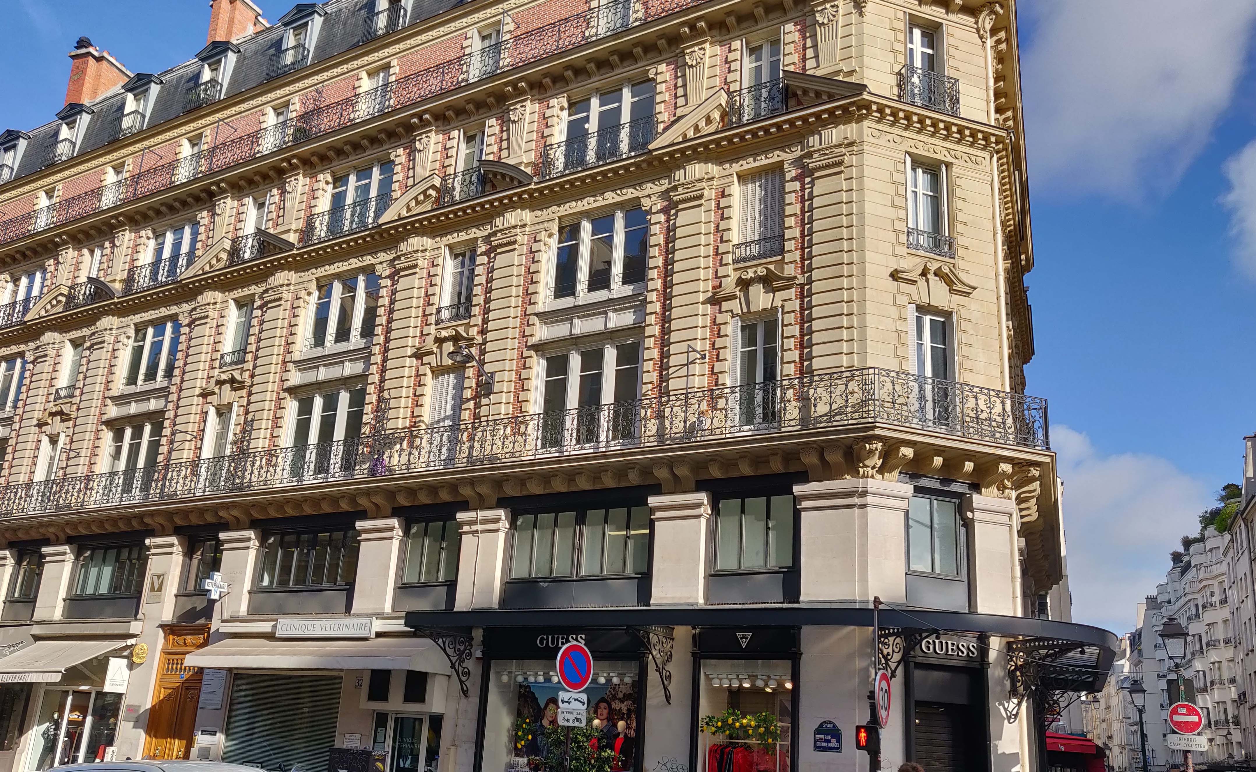 Traditional Parisian architecture in the 2nd arrondissement featuring ornate balconies and classic window design